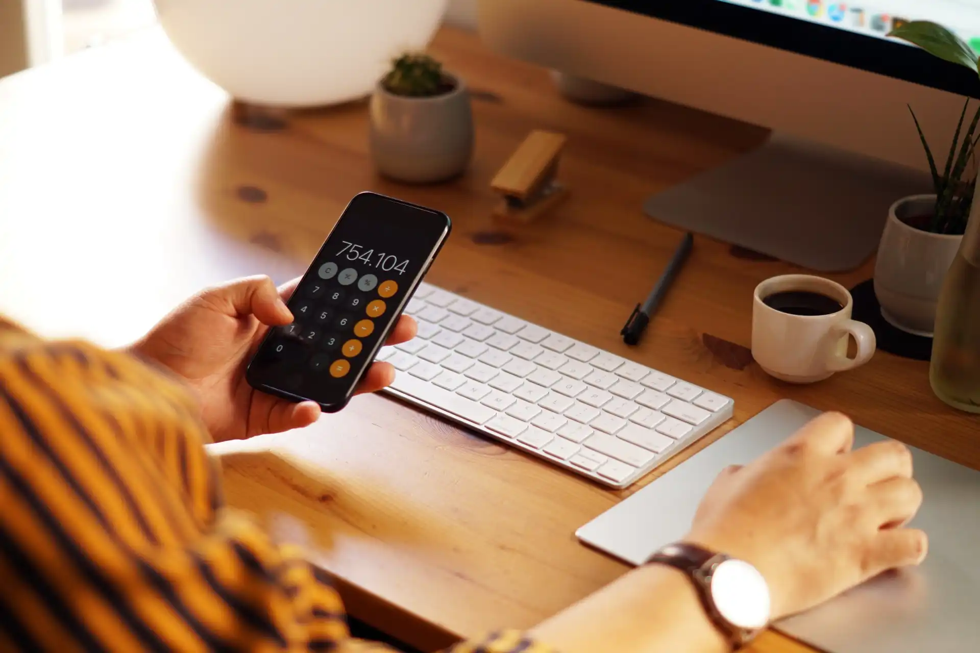 desk-side-view-of-a-person-using-a-mobile-calculator-app-to-analyze-long-term-investment-growth-and-tax-savings-for-a-family-trump-account-portfolio